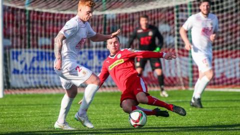Ports defender Chris Casement is tackled by Cliftonville winger Martin Donnelly