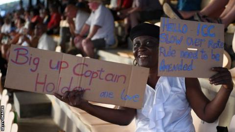 A fan holds up a sign in support of Jason Holder