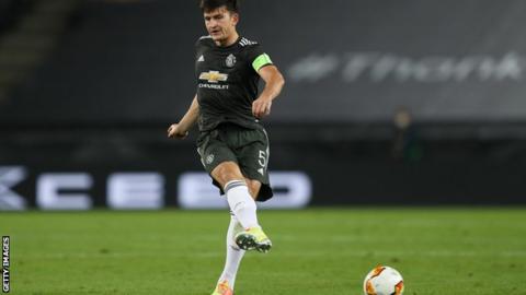 Harry Maguire kicks the ball while playing for Manchester United