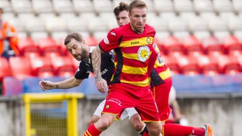 Partick Thistle's Ryan Stevenson fends off Dundee's Kevin Thomson