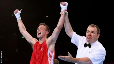 Josh Taylor's arm is raised to signify his win over Junias Jonas of Namibia in the men's 64kg final at Glasgow 2014