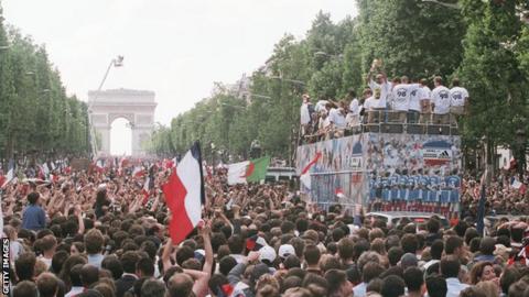 French fans during the parade on the Champs Elysees celebrate the French team's victory