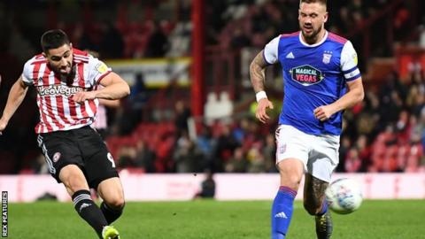 Bretnford striker Neal Maupay (left) shoots at goal