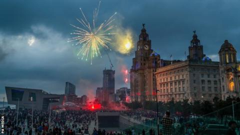 Fireworks are set off as crowds of Liverpool fans gather outside the Liver Building to celebrate the club's first Premier League title