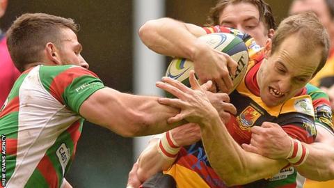 Carmarthen Quins' Lee Williams is tackled by Rhodri Jones and Rhodri Davies of Llandovery