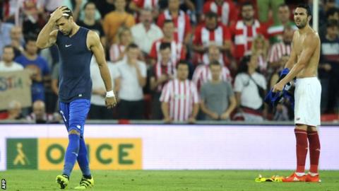 Sevilla keeper Salvatore Sirigu (left) leaves the field as midfielder Vicente Iborra takes over in goal