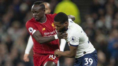 Spurs' Japhet Tanganga (right) tussles with Liverpool's Sadio Mane