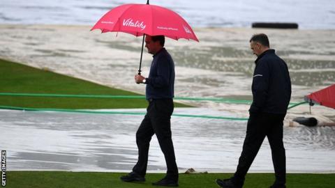 Umpires inspect a waterlogged pitch at Taunton