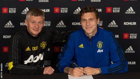 Victor Lindelof signing his new contract alongside Ole Gunnar Solskjaer.