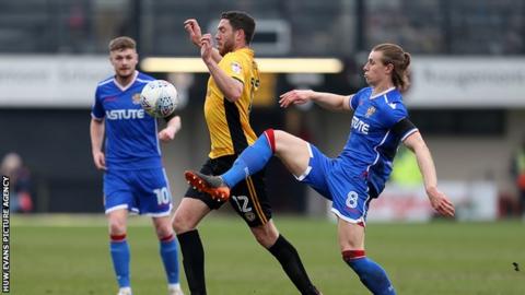 Ben Tozer of Newport County is challenged by Ben Sheaf of Stevenage