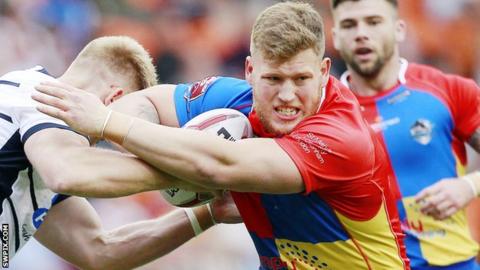 Lewis Bienek (centre) tussles with an opposition player
