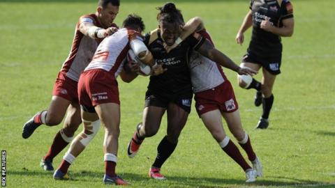 Atalea Vea trying to bust through a tackle against Catalans