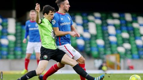 Warrenpoint's Danny Wallace challenges Linfield striker Andrew Waterworth