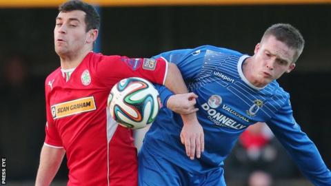 Cliftonville striker David McDaid and Dungannon's Andrew Burns tussle for the ball