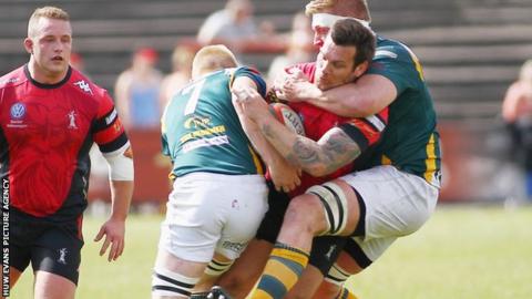 Chris Davies of Aberavon is tackled by Osian Davies and Craig Locke of Merthyr
