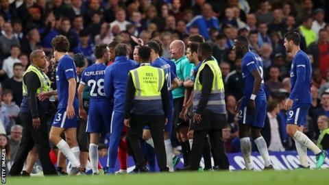 Lee Mason surrounded by Chelsea players