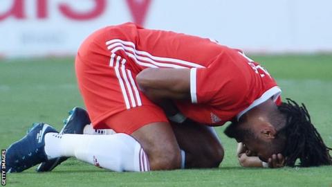 Wales captain and defender Ashley Williams holds his side in pain