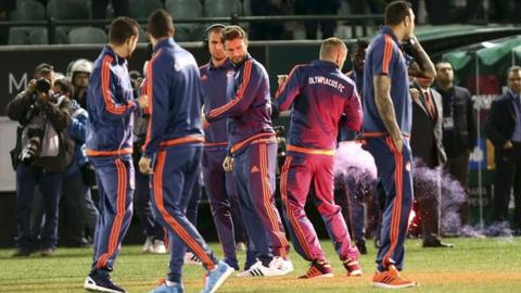 Olympiakos striker Alfred Finnbogason is hit by a flare