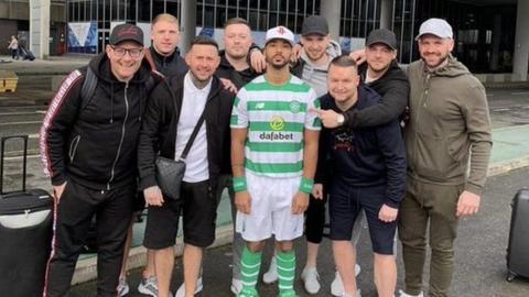 Shay Logan (centre) wearing a Celtic shirt