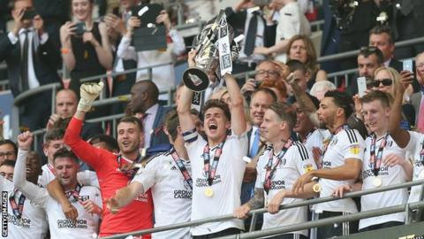 Tom Cairney lifts the Championship play-off trophy aloft at Wembley