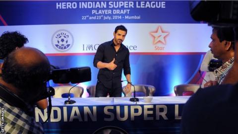 Bollywood actor John Abraham gives a thumbs up at a news conference for the Indian Super League