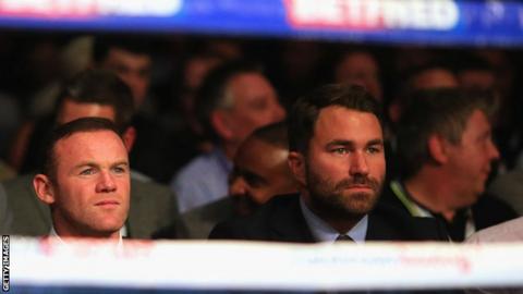 Wayne Rooney sits with Eddie Hearn ringside