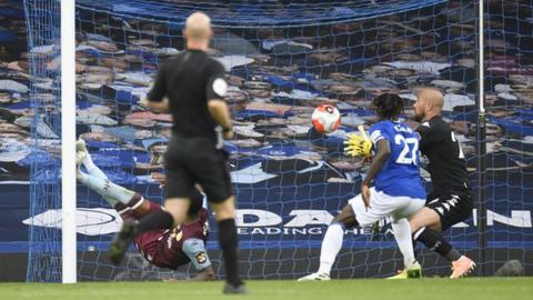 Ezri Konsa is unable to keep out Theo Walcott's header