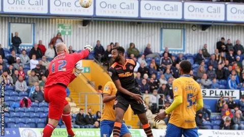 Brian Jensen of Mansfield clears the danger from Zak Ansa