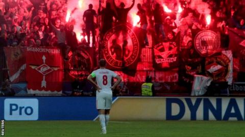 Spartak Moscow"s Denis Glushakov as fans set off flares in the stands