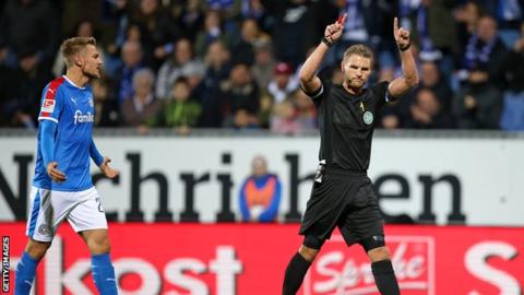 The referee awarding a penalty to Bochum after a VAR check
