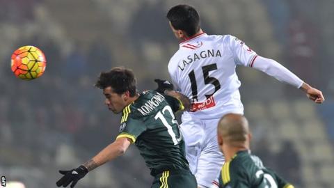 AC Milan defender Alessio Romagnoli (left) jumps for the ball with Carpi's Kevin Lasagna