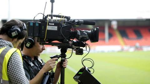 A television cameraman prepares to shoot a football match