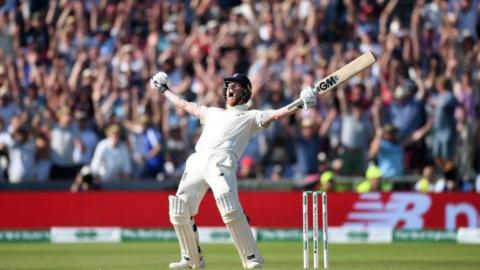 Ben Stokes roars in celebration with both arms aloft brandishing his bat