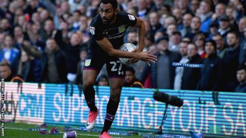 Ahmed Elmohamady of Aston Villa removes debris from the pitch during Sunday's second city derby