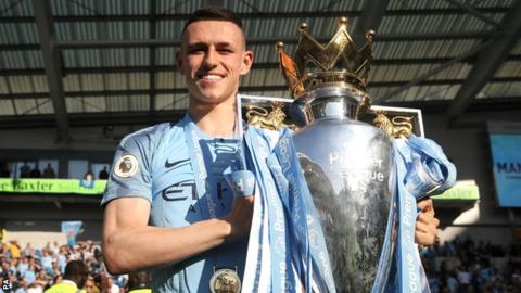 Phil Foden holds the Premier League trophy