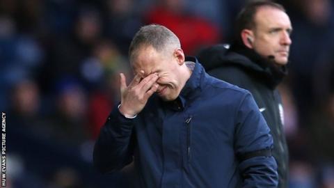 Steve Cooper rubs his eyes in despair during Swansea' heavy defeat at the Hawthorns