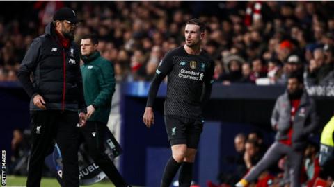 Jordan Henderson feels his hamstring as he walks off the pitch