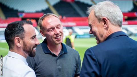 Leon Britton, Steve Cooper and Swansea City chairman Trevor Birch chat before a game