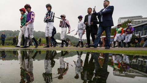 Jockeys make their way to the parade ring at Nottingham Racecourse