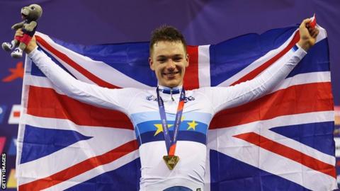 Britain's Ethan Hayter holds up the Union Jack as he celebrates on the podium after winning omnium gold at the 2018 European Championship