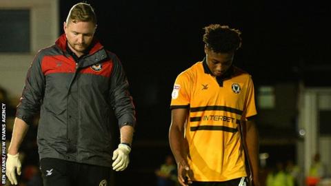 Newport striker Antoine Semenyo is escorted from the pitch after his head injury against Oxford United