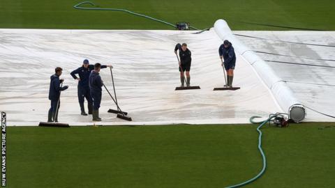 The staff at Glamorgan try and work on the pitch before the match with Surrey was abandoned
