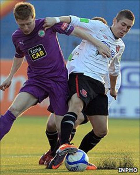 Stephen Garrett of Cliftonville battles for the ball against Daniel Kearns of Dundalk