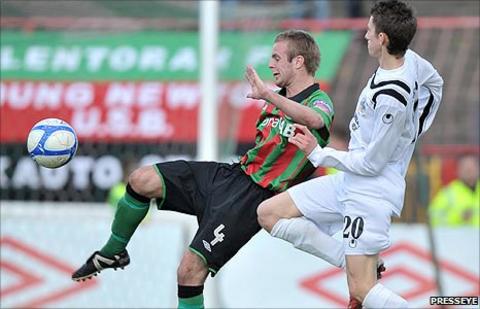 Glentoran's Richard Clarke in action against Jordan Forsythe of Lisburn Distillery