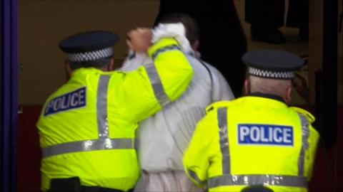 A man is led away by police in Tynecastle