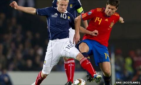 Steven Naismith challenges Spain midfielder Xabier Alonso