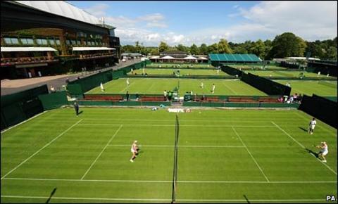 Competitors warm up on Wimbledon's grass during a sunny spell
