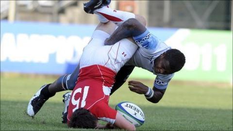 Wales full-back Ross Jones is upended by Fiji's Solomoni Rosolea
