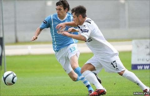 Mark Surgenor of Ballymena United competes for possession with Lisburn Distllery's Jordan Hughes