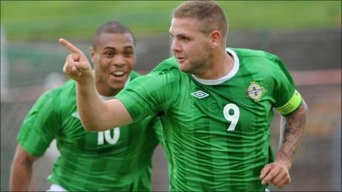 Josh Magennis runs to congratulate hat-trick hero Billy Kee